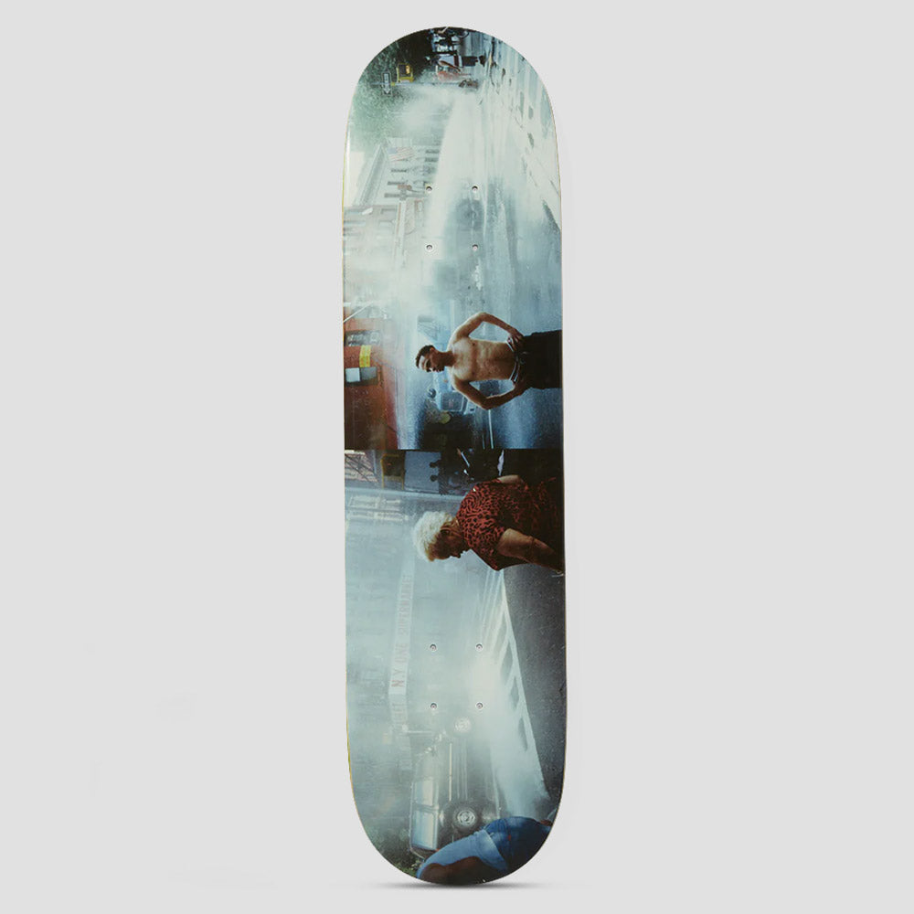 HUF Lost My Way Home Multi skateboard deck: Full-length photographic print of a wet city street scene, shown sideways along the deck: a shirtless man with raised arms, an older woman in a leopard-print top, a fire hydrant spray and parked cars.