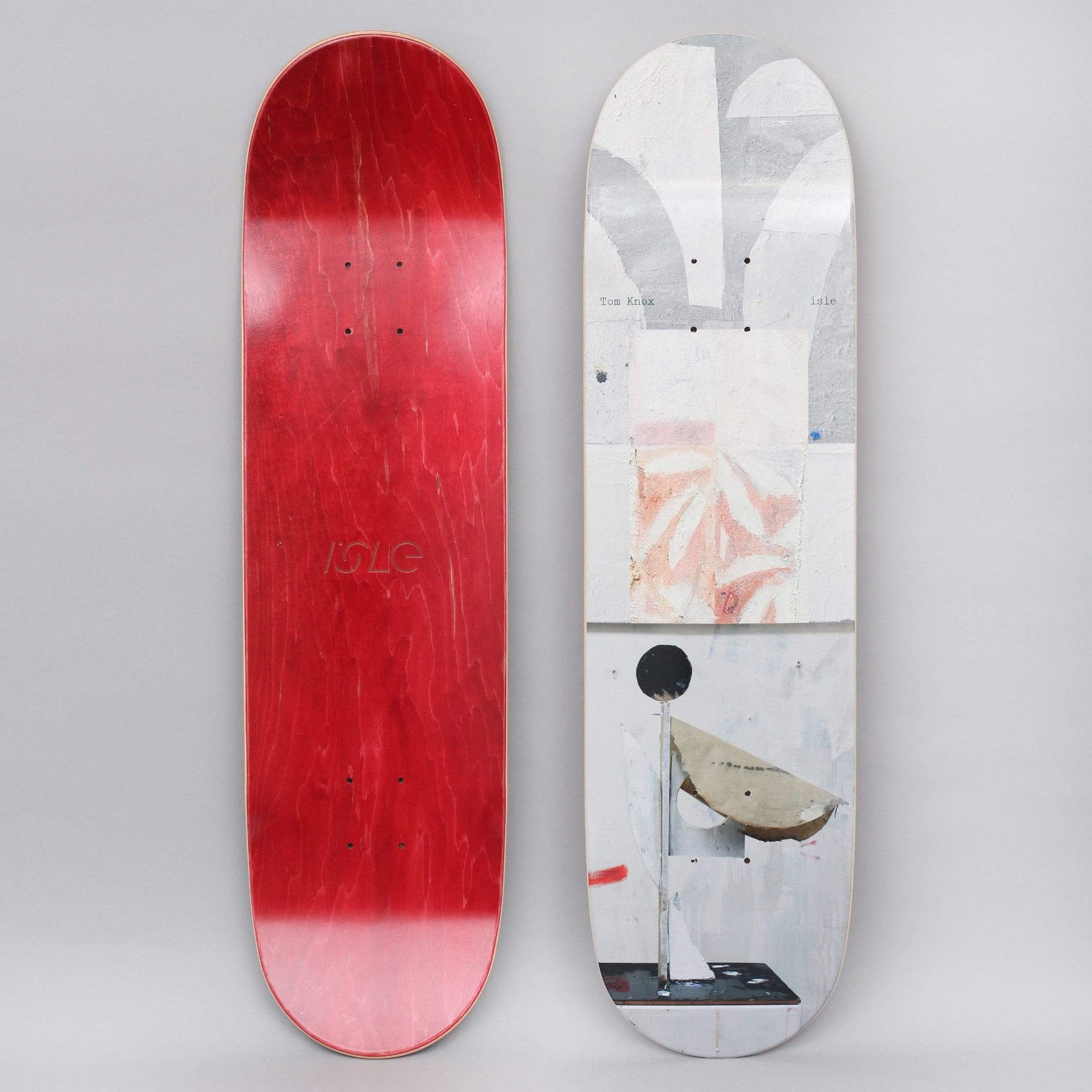 Isle Knox Sculpture Series skateboard deck: Photograph of a pale collage-like sculpture with torn paper shapes, a black ball on a stem and a curved cardboard bowl, against a white painted wall. Small rider and brand text at the top; underside is red with the Isle logo.