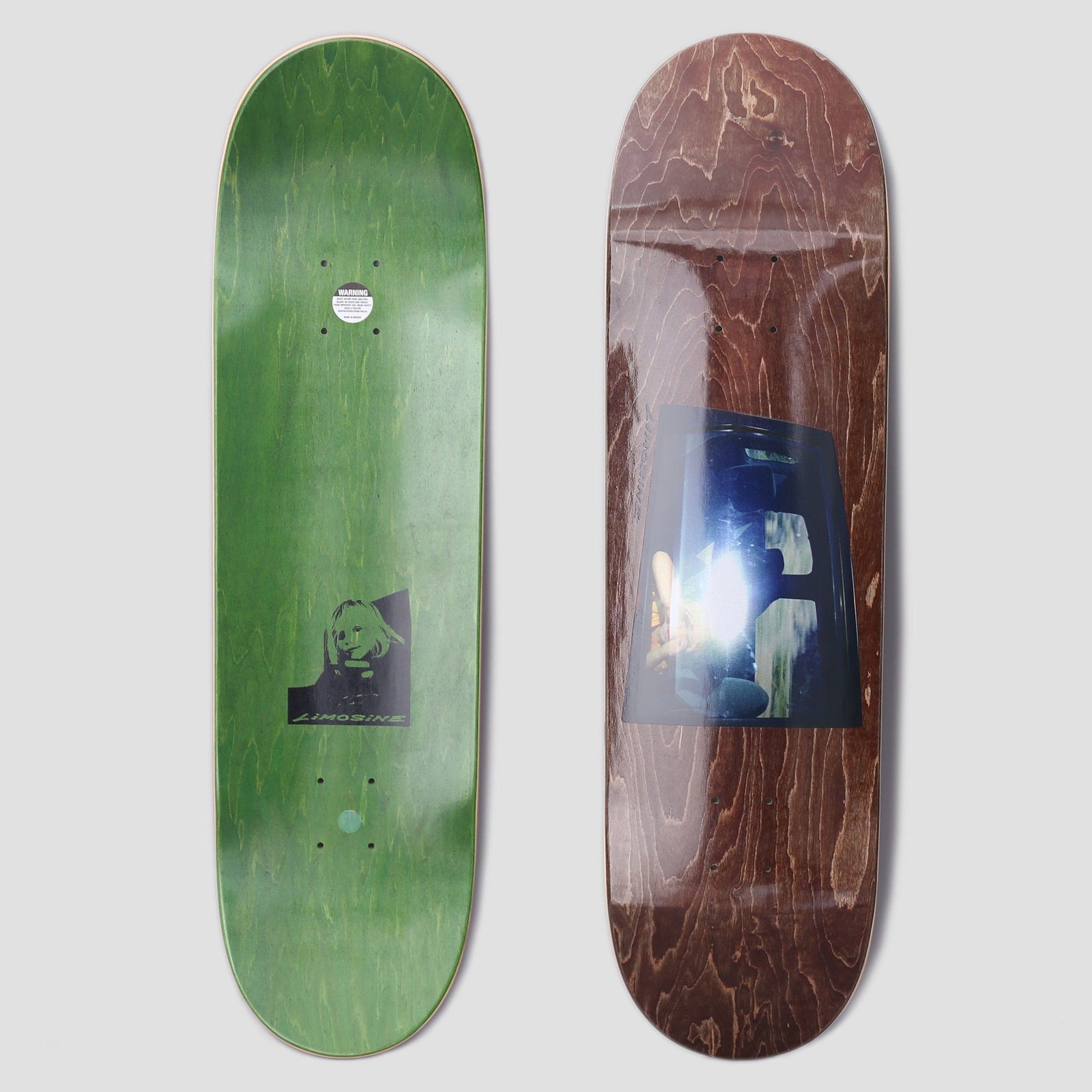 Limosine Cyrus Bennett Window Brown skateboard deck: Brown stained deck with a bluish photographic print of a car window, showing bright light flare and shadowy figures inside. The reverse is green stain with a small black and white portrait and the Limosine name.