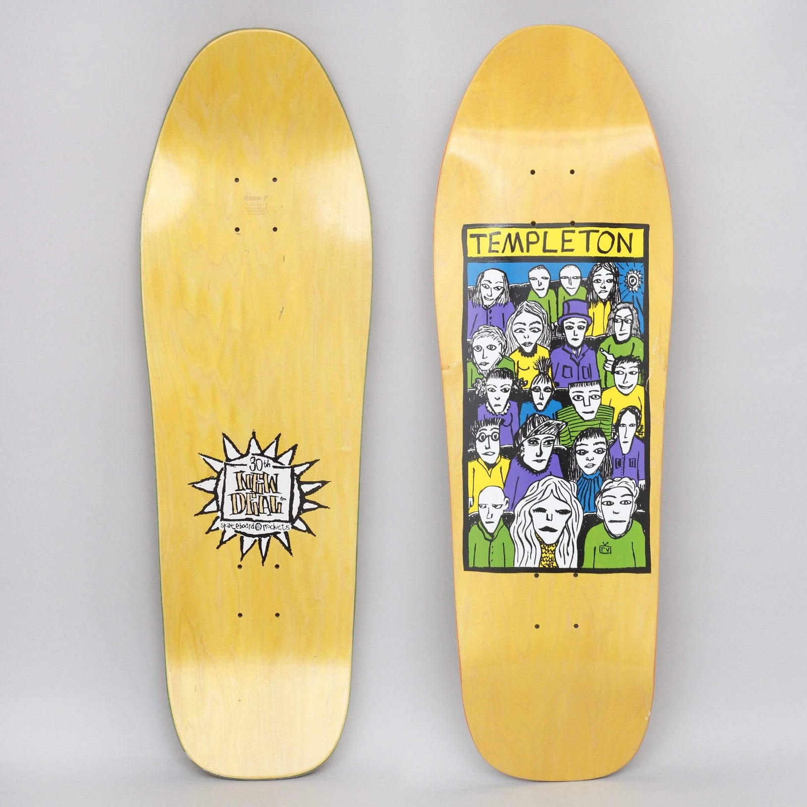 New Deal Templeton Crowd SP Yellow skateboard deck: A framed, hand-drawn crowd of staring faces in purple, green, yellow and blue, with a yellow title banner above. The yellow-stained deck is shown from both sides, with a spiky sun logo on the underside.
