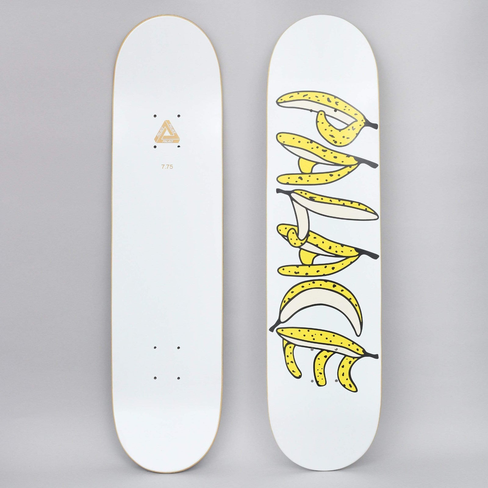 Palace Banana White skateboard deck: Cartoon yellow bananas, some peeled, arranged to spell out the Palace name vertically on a white deck. The photo also shows the white underside with a gold Tri-ferg logo.