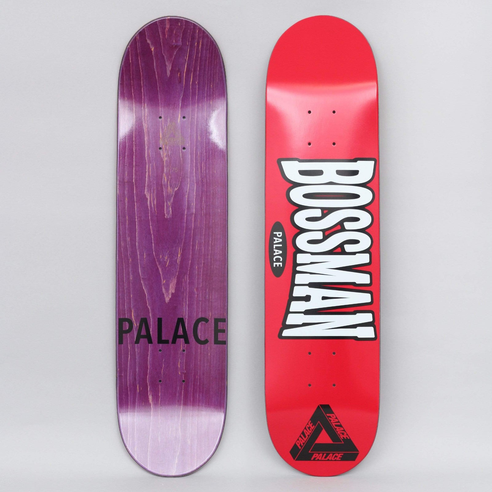 Palace Bossman Red skateboard deck: A red deck with large white outlined, curved Bossman lettering over a small black Palace oval, and the Palace triangle logo in black at the tail. The underside is purple-stained with Palace text.
