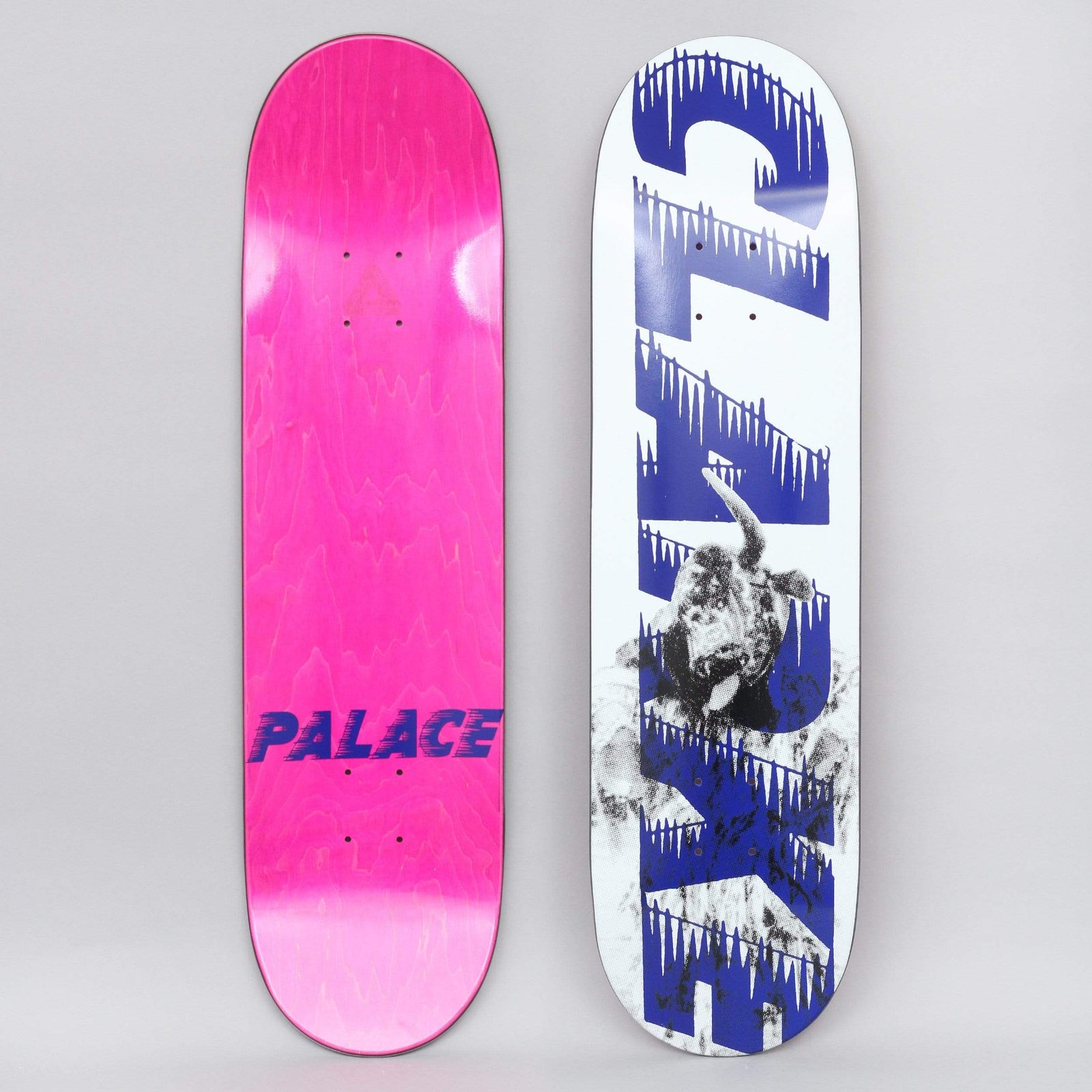 Palace Clarke S21 skateboard deck: Large blue Palace-style lettering with icicles dripping from it, running down a white deck over a grainy black and white photograph of a snarling bull terrier dog. The underside is pink with a blue Palace logo.