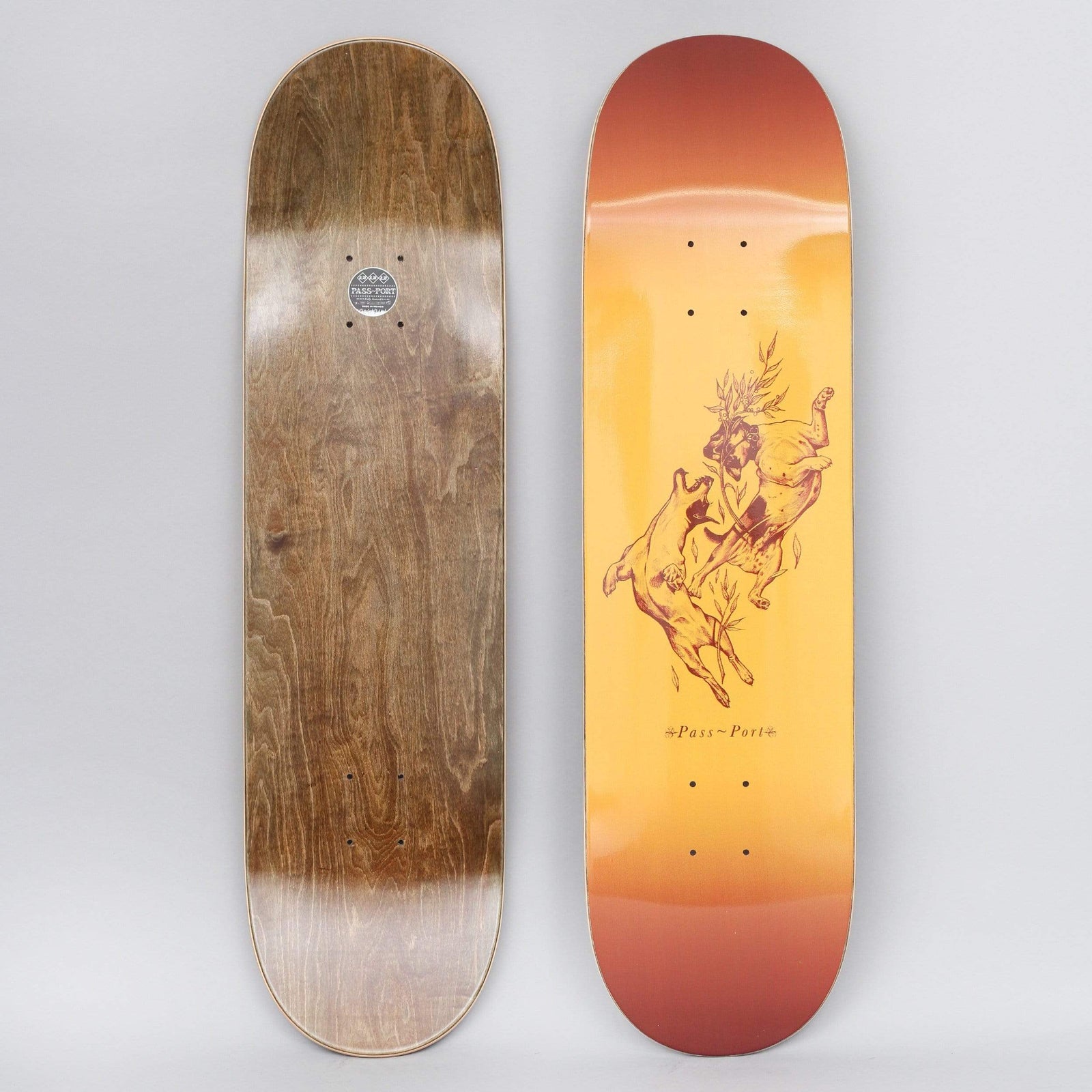 Passport Doggo Sunburst skateboard deck: Maroon line illustration of a dog or wolf leaping at a crouching figure with foliage around its head, set on an orange-to-red sunburst gradient. Small logo text below.