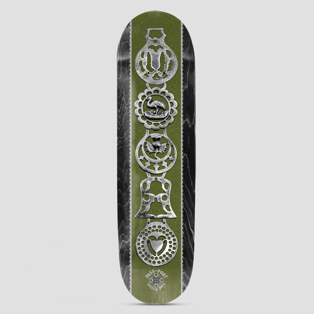 Passport Brasses Pro Series Callum skateboard deck: Photographic stack of five silver horse brasses, including a bird, a bell and a heart, down a green central panel with black wood-grain edges. Pass~Port and the rider's name appear in a small logo at the bottom.
