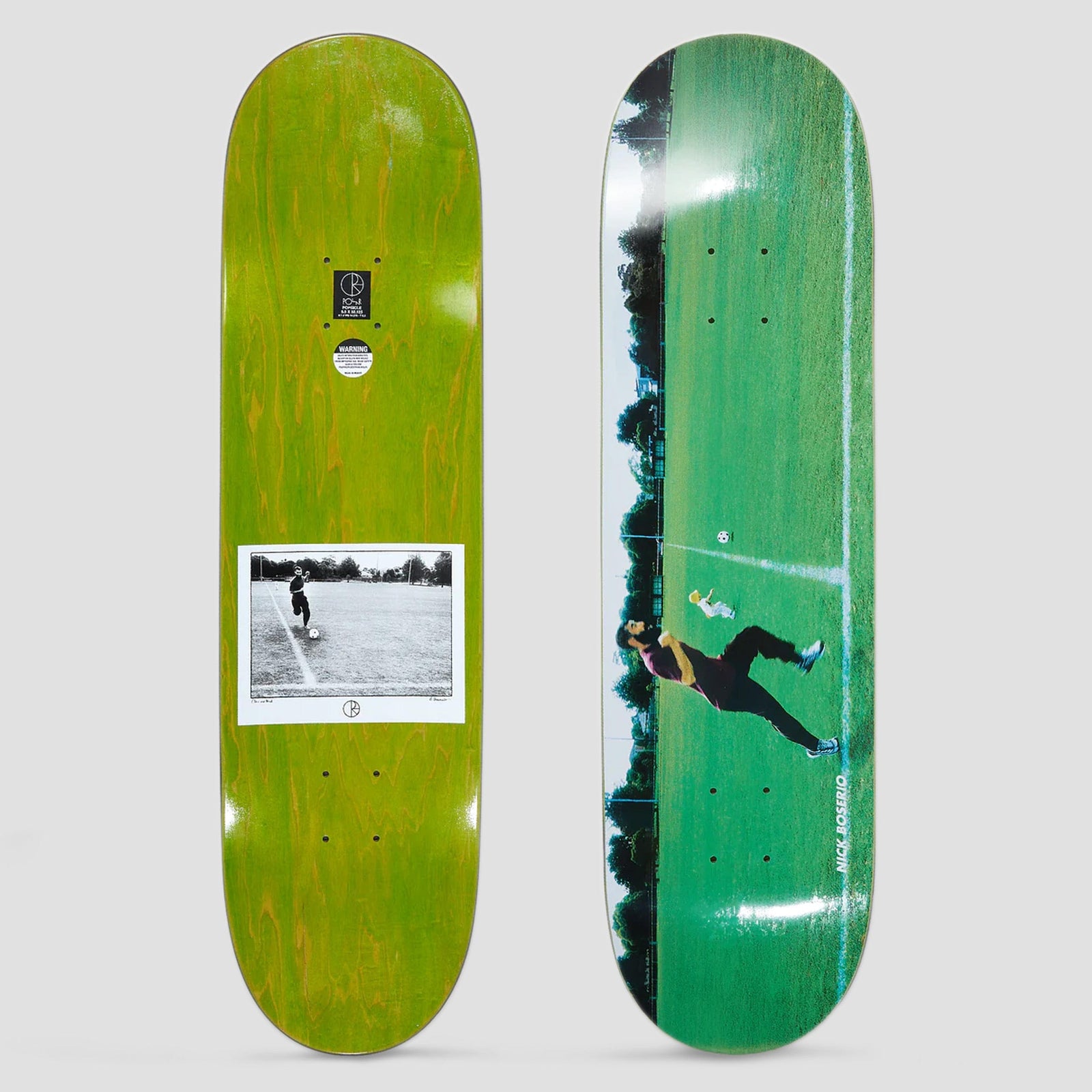 Polar Nick Boserio Cleo Run Green skateboard deck: A colour photograph of a person in dark clothes mid-kick of a football on a green grass pitch, with a white line marking and trees behind. The name runs up the right edge. The underside carries a black and white version of the photo.