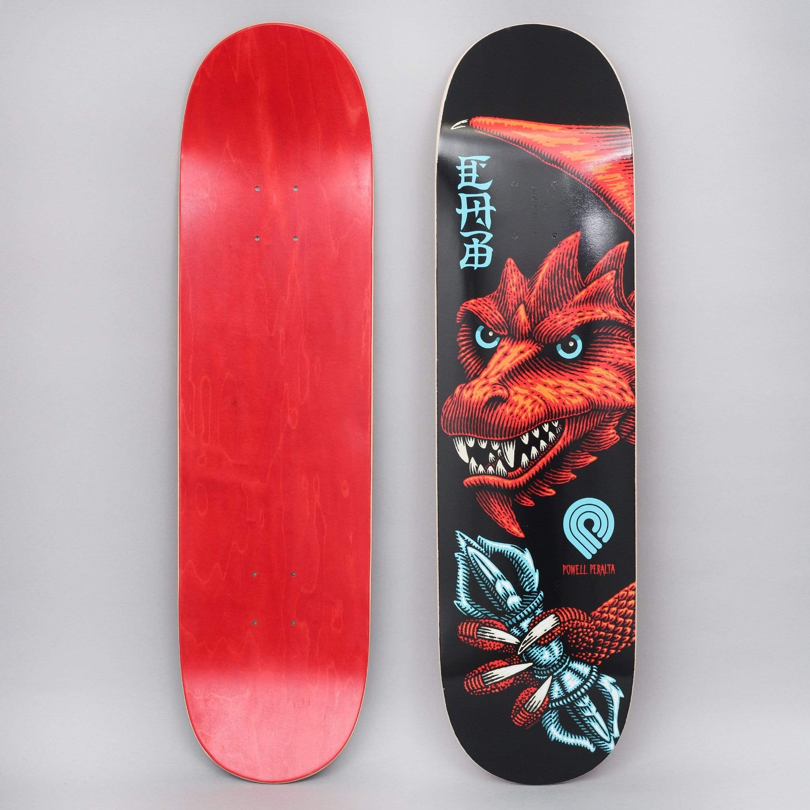 Powell Peralta Peralta 8.25 Cab Dragon Wing 243 skateboard deck: A red dragon's head with blue eyes and bared teeth, with a wing behind, and a claw gripping a blue vajra-like object, on a black deck with Chinese-style characters and a Powell Peralta logo. Photo shows the underside too.