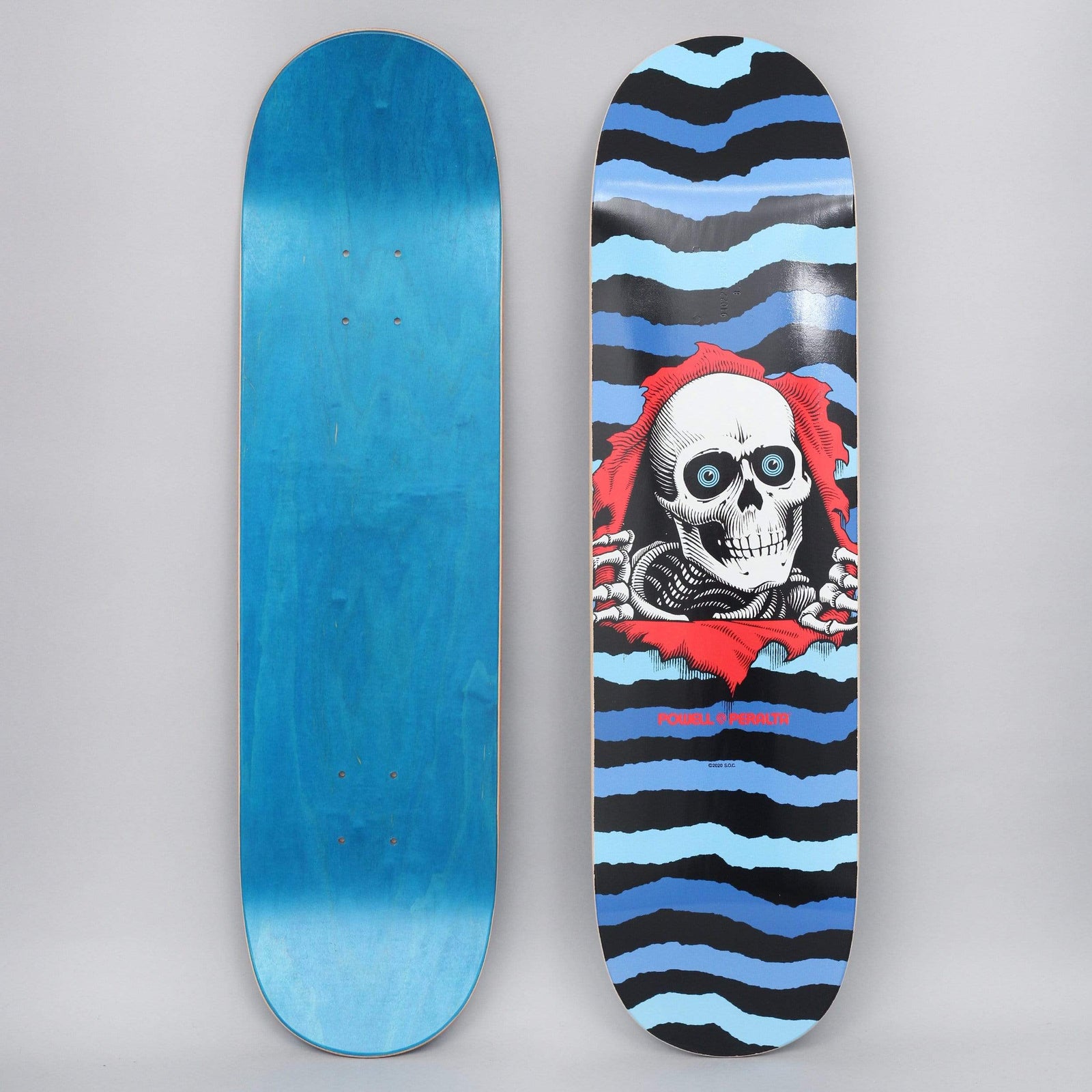 Powell Peralta Peralta 8.25 Ripper Shape 243 Blue skateboard deck: The Ripper skull bursting through torn red paper, with skeletal hands gripping the tear, set against jagged horizontal stripes in blues and black. Powell Peralta name in red beneath.