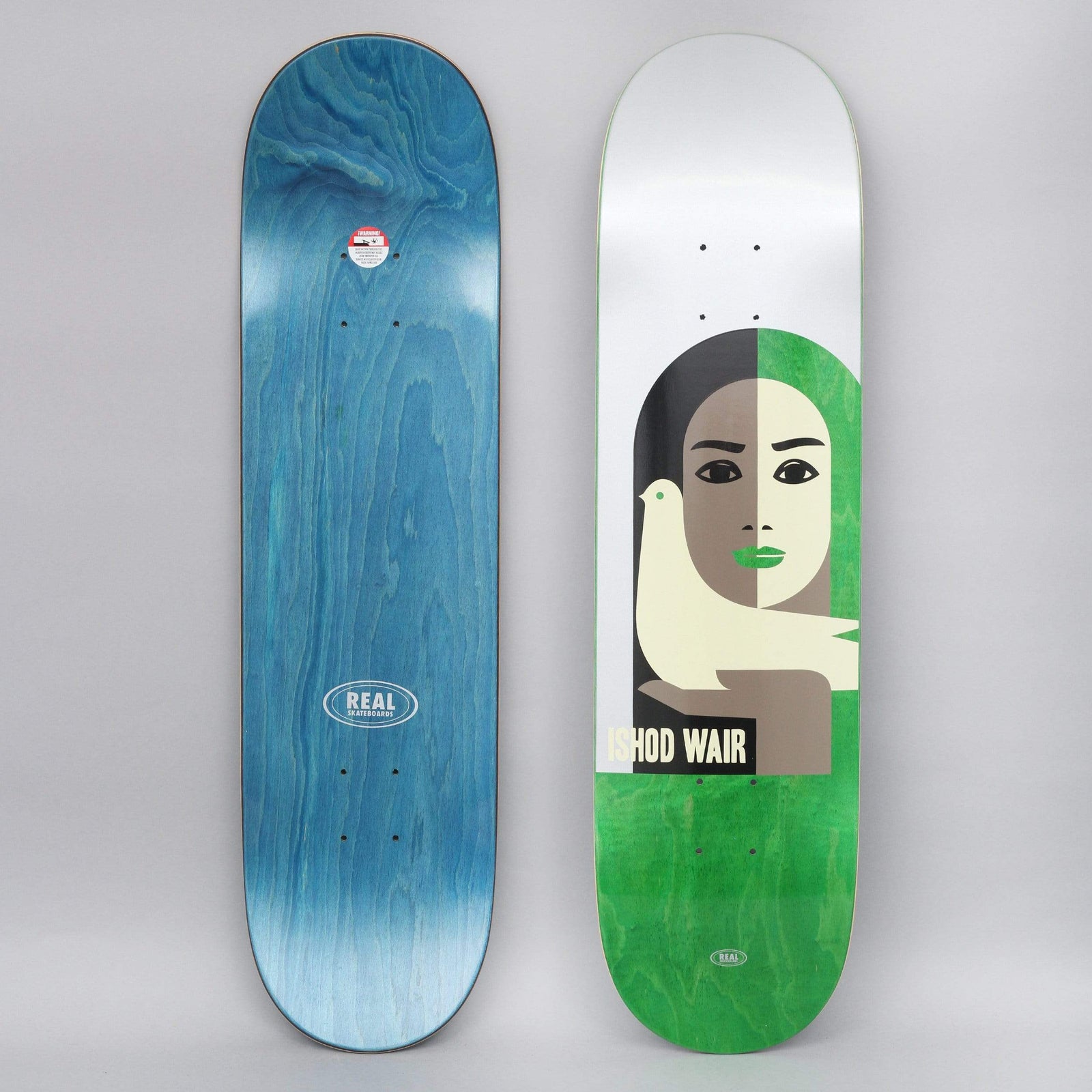Real Ishod Peace skateboard deck: Stylised flat illustration of a woman's face split down the middle, brown on the left and green on the right with green lips, with a cream dove perched in front of her. Silver top, green stained lower deck.