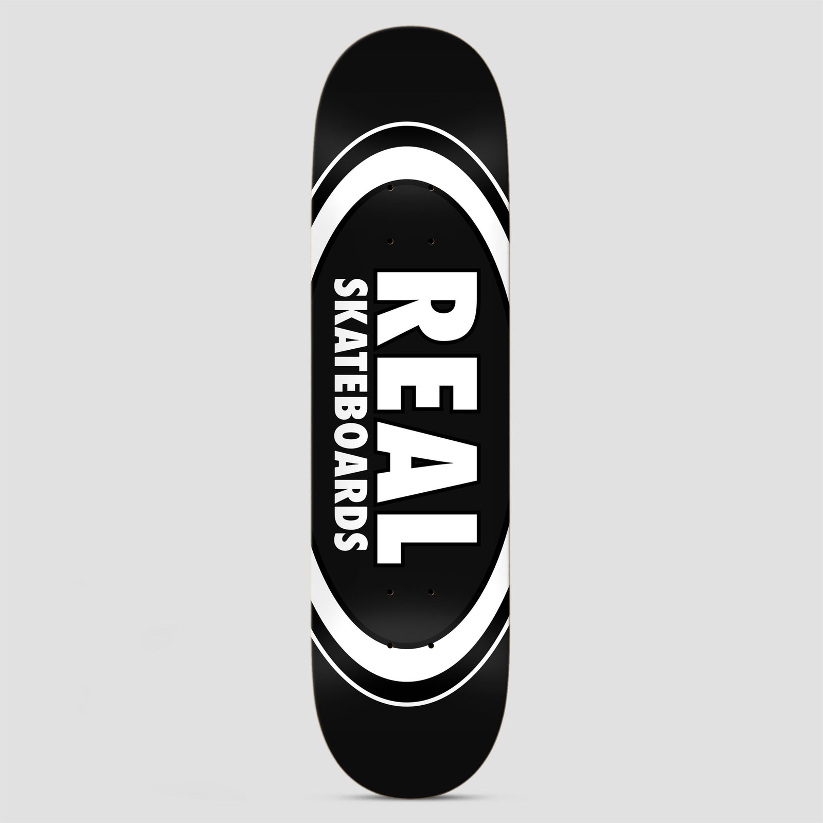 Real Team Classic Oval Black skateboard deck: Black deck with a large white oval logo, outlined in concentric rings, containing REAL in big white capitals with Skateboards in smaller capitals alongside.