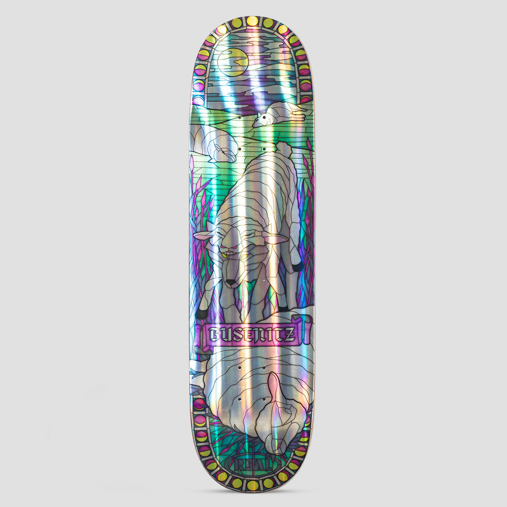 Real Dennis Holographic Cathedral Multi skateboard deck: A stained-glass window design printed on holographic foil, showing a lamb under a crescent moon and a bird, with reeds at the sides. A second lamb lies upside down at the bottom, with a roundel border of circles and a gothic 'Busenitz' plaque.