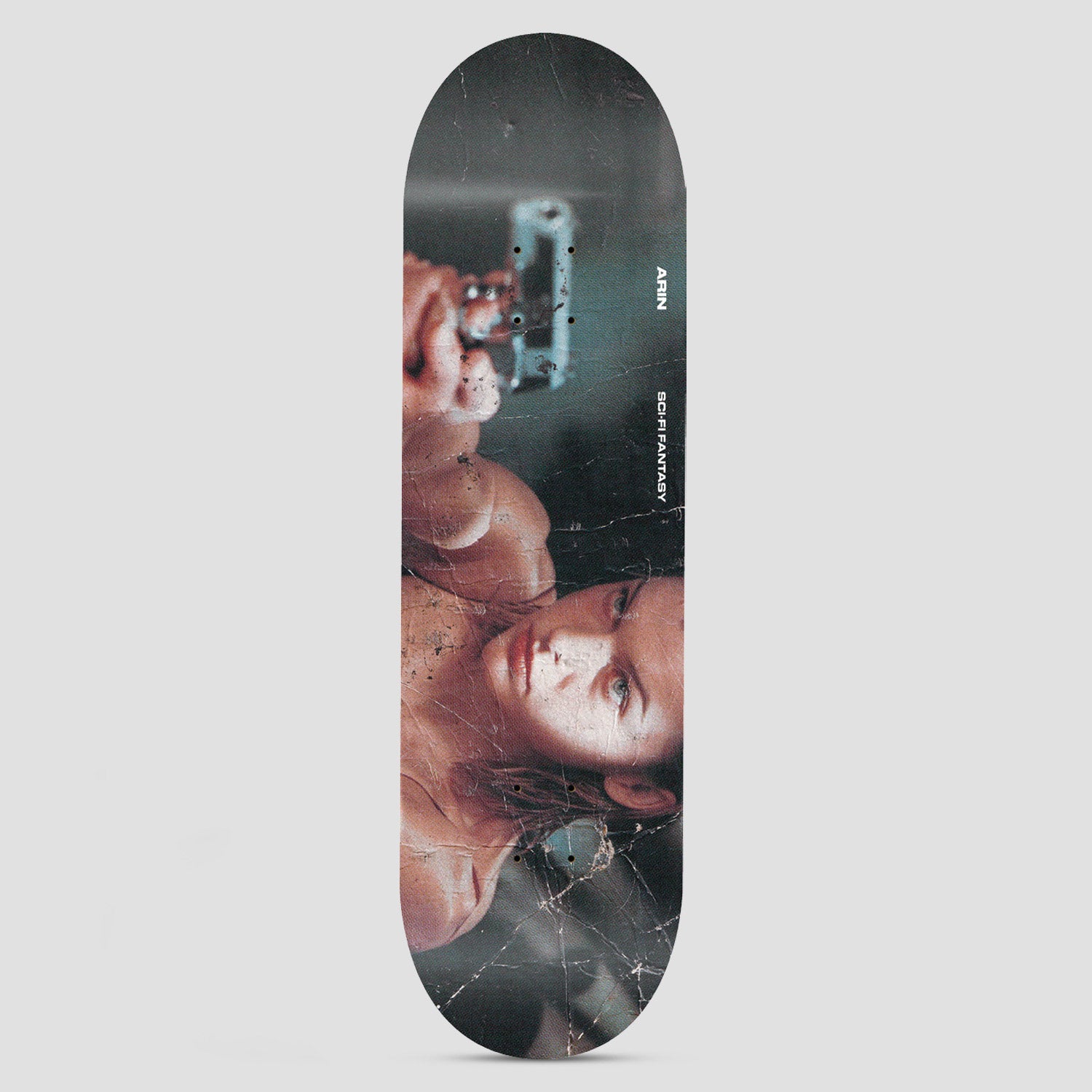 Sci-Fi Fantasy Arin Evil Multi skateboard deck: Weathered, cracked-looking photograph of a woman with her arm raised, pointing a handgun, in a moody teal and skin-tone palette. Small white text runs down the side.