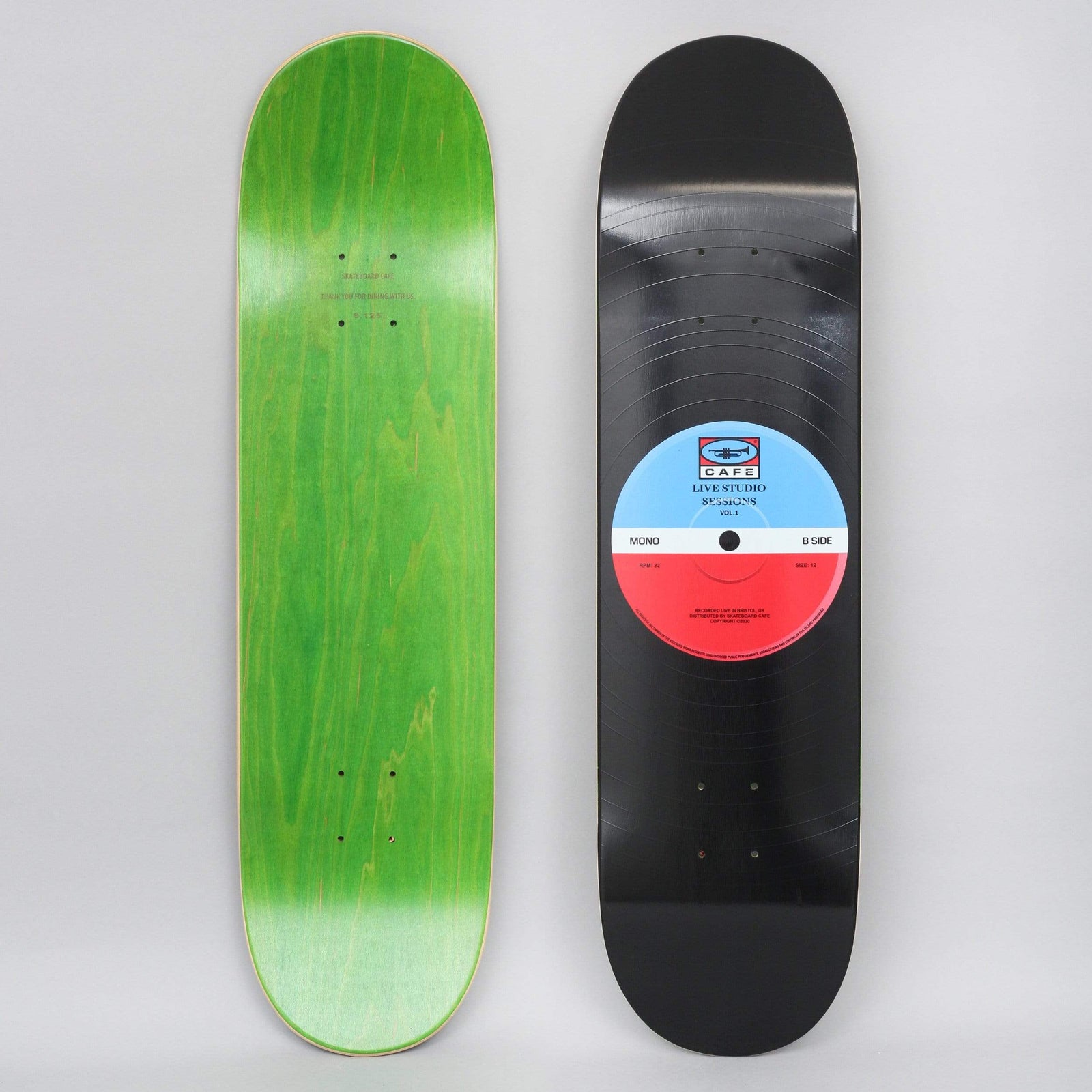 Skateboard Cafe 45 Blue / Red skateboard deck: Black deck made to look like a vinyl record, with fine grooves and a blue and red centre label carrying a Cafe logo and record-sleeve style text. The underside is green.