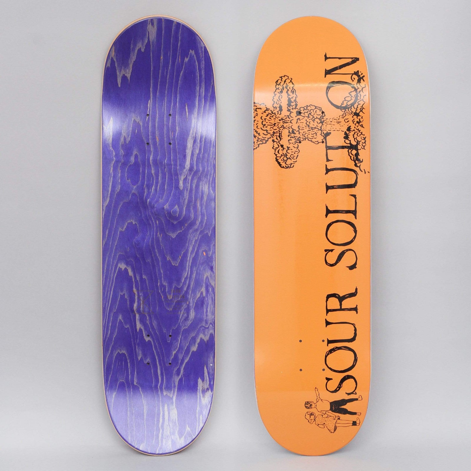 Sour Nuclear Orange skateboard deck: Orange deck with a black ink mushroom cloud explosion at the nose, with the word 'Sour Solution' in large serif capitals running down the board and a small drawing of two children at the tail. Underside is purple-stained.