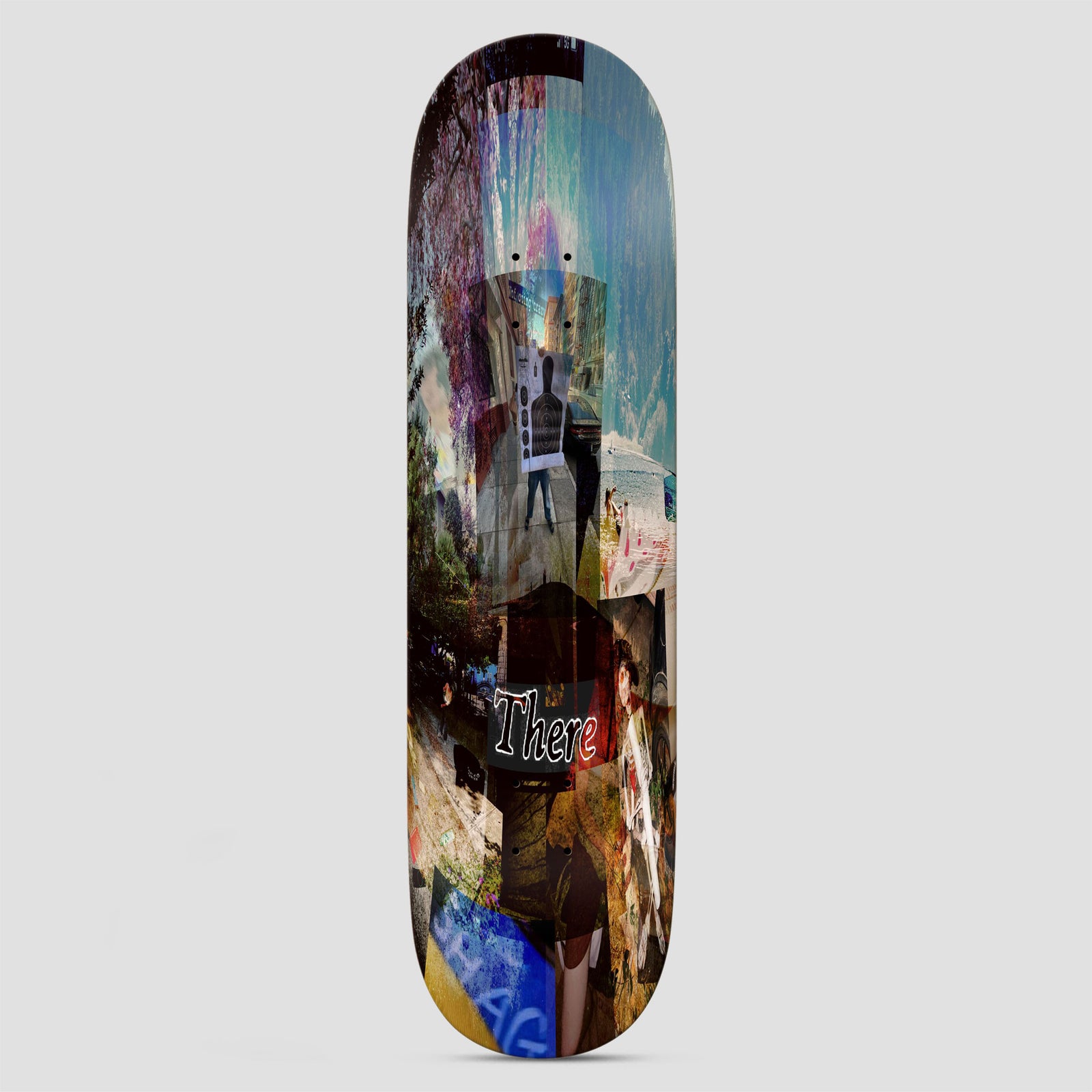 There Shag Sees All skateboard deck: Layered, blurred photo collage of street scenes, trees, sky and a target silhouette, with the word There in white outlined italic script near the middle and a blue graffiti-style tag near the tail.