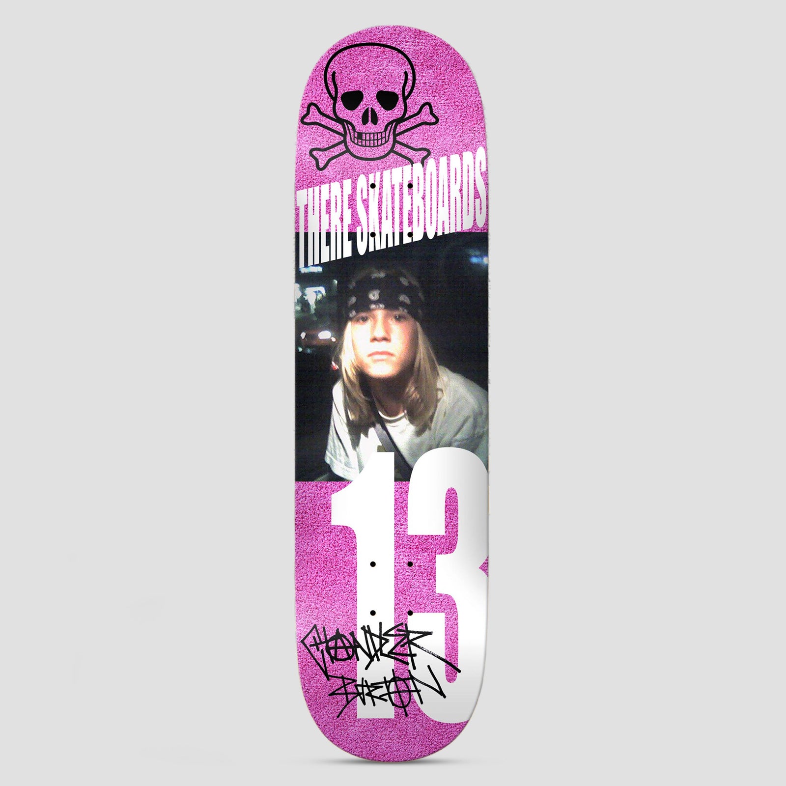 There Chandler 13 Pink skateboard deck: A skull and crossbones outline above a photo of a long-haired kid in a bandana, with a huge white '13' and a scrawled signature, on a speckled pink background.