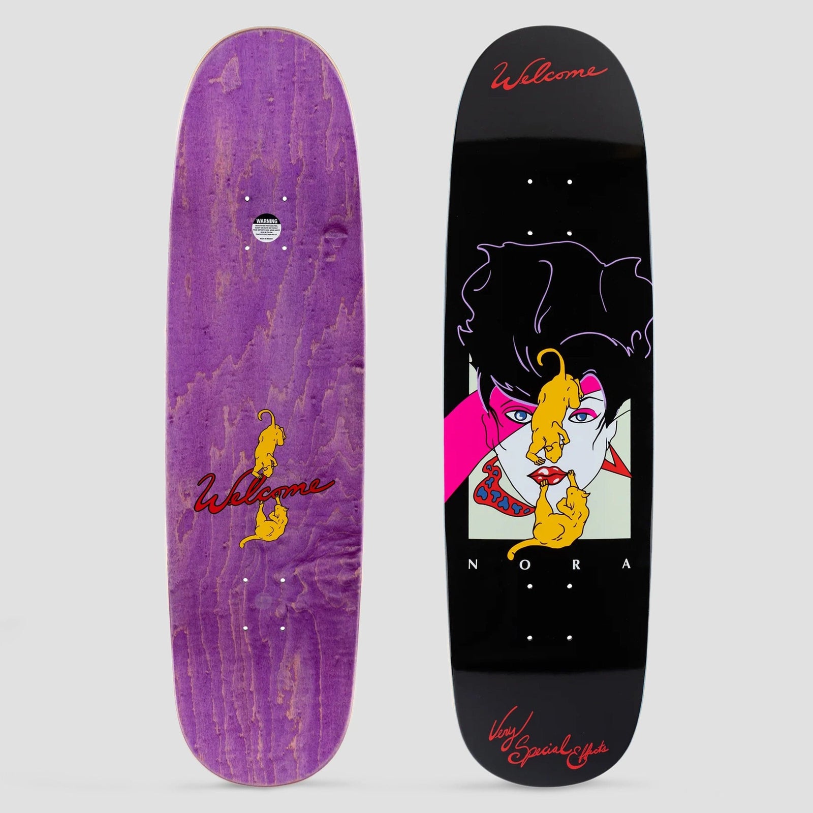 Welcome Special Effects Nora Pro Model on Sphynx Black skateboard deck: A retro 1980s-style illustration of a woman with black hair, pink eye make-up and red lips, with two golden cats climbing over her face, on black. Red script lettering at nose and tail; the underside is shown in purple stain.