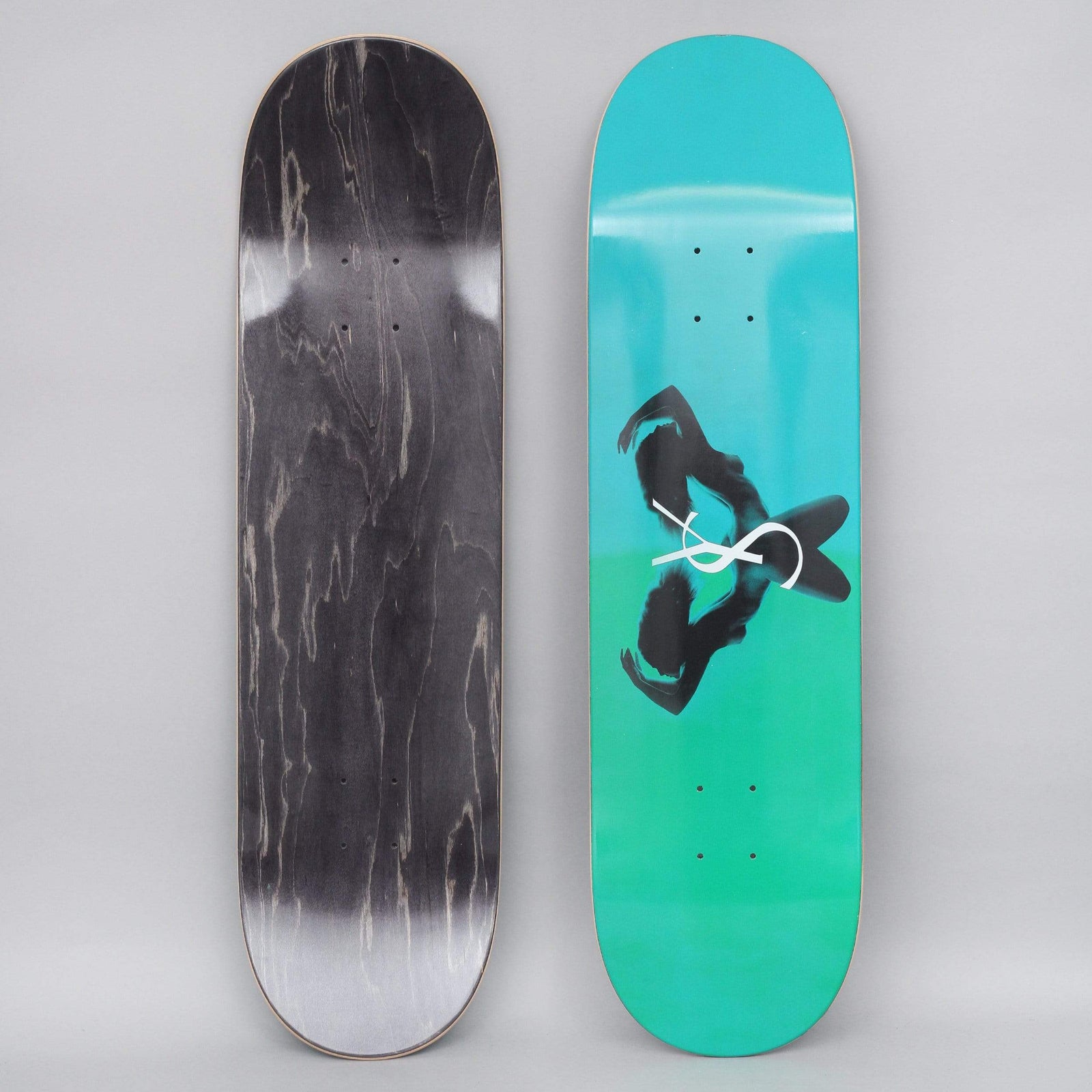 Yardsale Utopia Emerald skateboard deck: Teal to green gradient deck with a dark silhouetted pair of figures in mirrored poses, crossed by a white interlocking ampersand-like logo. The reverse is black stain.