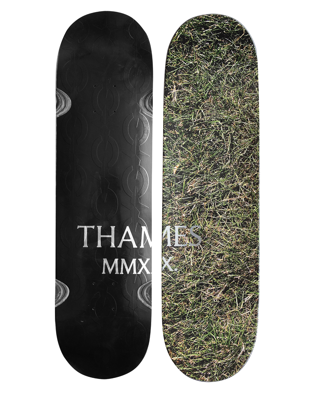 Thames MMXX Starlink skateboard deck: One side shows a close-up photo of dry grass; the other is black with embossed chain-link pattern, both carrying silver 'THAMES MMXX' serif lettering across the middle.
