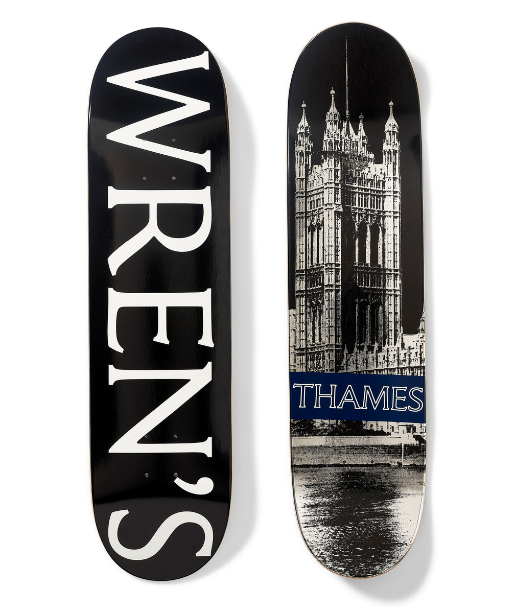 Thames MMXX Wrens Board skateboard deck: Two decks. One is black with huge white serif 'WREN'S' running down its length. The other is a black and white photo of a Gothic Revival tower beside a river, with a navy band reading THAMES across the lower part.