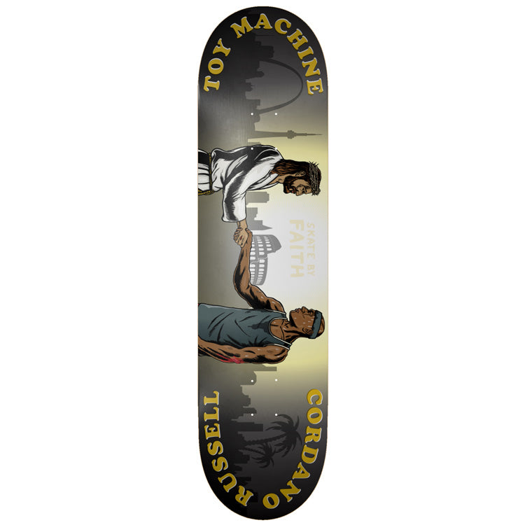 Toy Machine Cordano Russell Skate By Faith 8.50 skateboard deck: Illustration of a robed, bearded Jesus-like figure shaking hands with a muscular man in a vest and headband, against a faded skyline with the Colosseum and palm trees. Gold curved text names Toy Machine, Cordano and Russell.