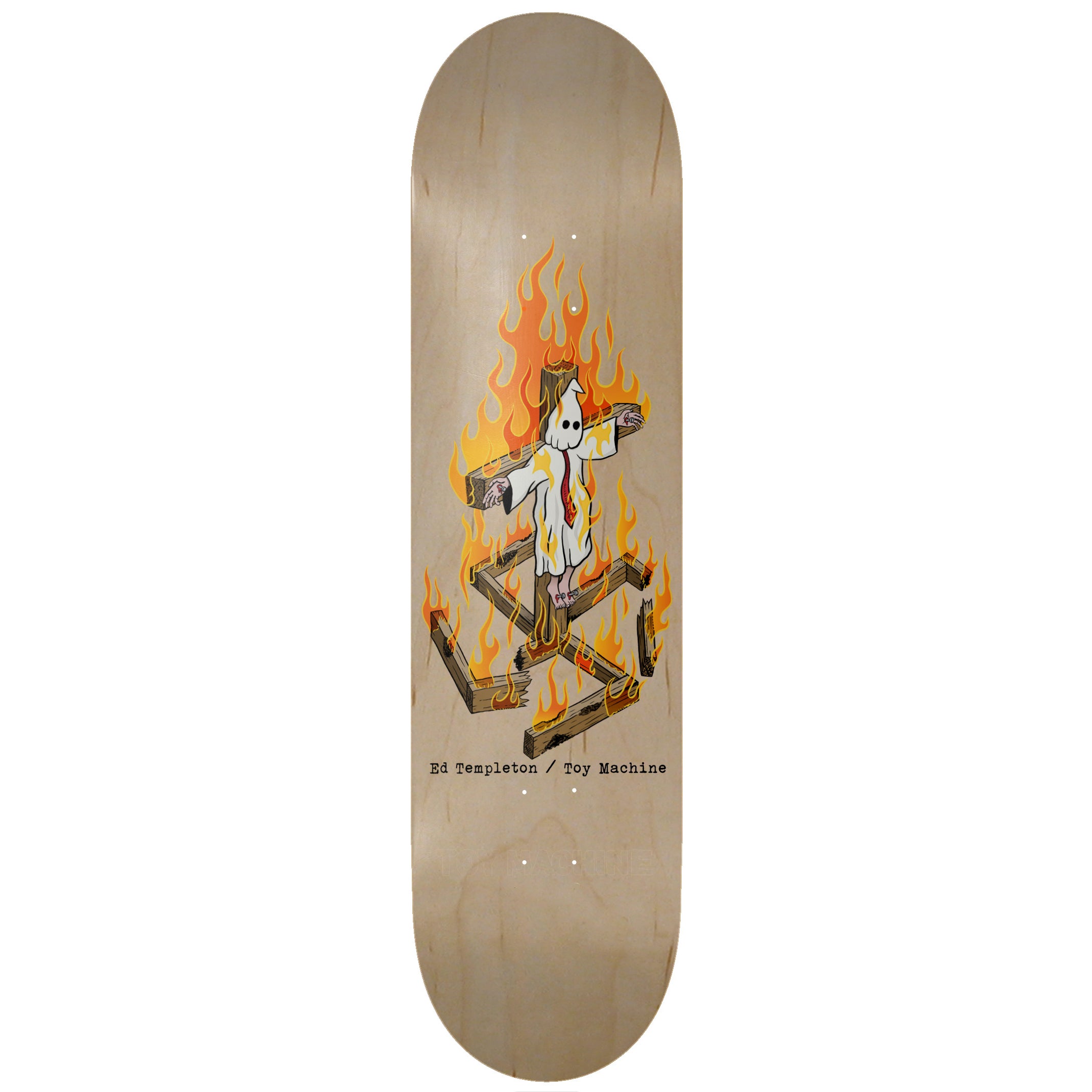 Toy Machine Ed Templeton Charred Cross 8.50 skateboard deck: A figure in a white pointed hood and robe with a red tie hangs from a burning wooden cross, with charred timbers burning below. Typewriter-style rider and brand credit beneath, on natural bare maple.