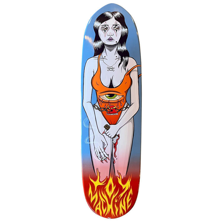 Toy Machine Halloween Girl 8.63 skateboard deck: Egg-shaped deck showing a pale woman with clown-style face paint in an orange swimsuit with a chained one-eyed Toy Machine emblem, holding a cigarette and a bloody knife. Blue to pink sky fades into red with yellow flame lettering at the tail.