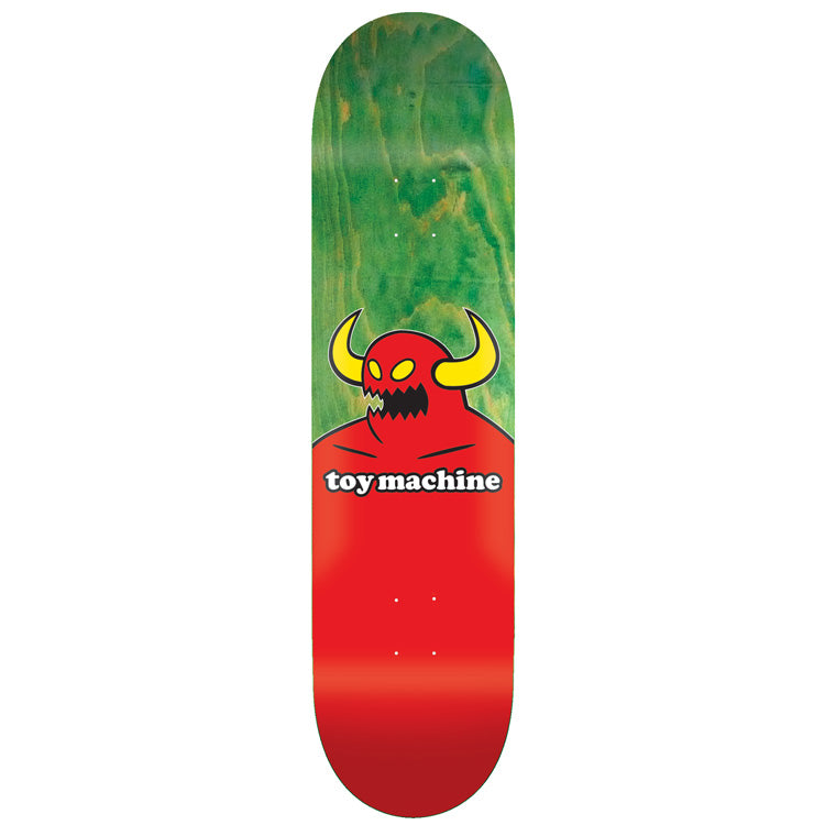 Toy Machine Monster 7.50 skateboard deck: Toy Machine's red horned monster with yellow horns and a jagged black mouth, shown from the chest up with the Toy Machine wordmark across its body, on a green-stained wood top fading into red.