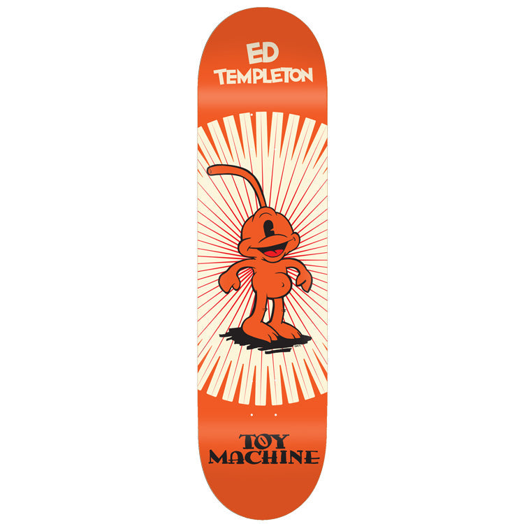 Toy Machine Ed Templeton Toons 8.75 skateboard deck: Vintage cartoon-style orange one-eyed character with a curved tail standing in front of a cream and red sunburst. 'Ed Templeton' at the top and 'Toy Machine' in serif lettering at the bottom, on an orange deck.
