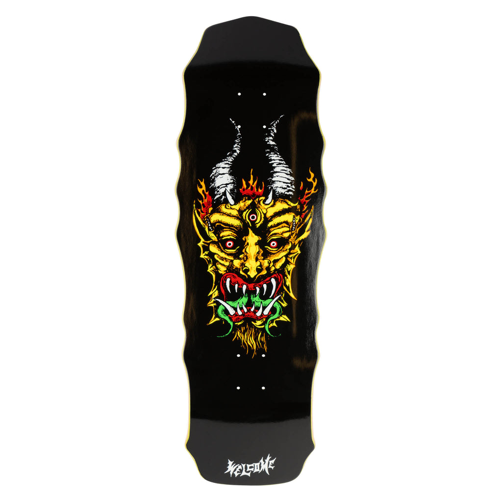 Welcome Light & Easy on Widow - Black skateboard deck: A three-eyed yellow demon mask with curved grey horns, flames, fangs and a goatee, printed on a black shaped deck. The Welcome logo sits in white at the tail.