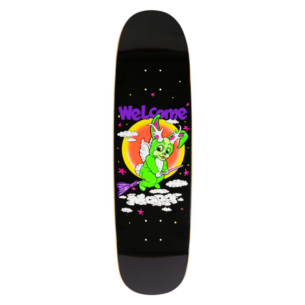 Welcome Nora Vasconcellos Full Moon on Sphynx - Black skateboard deck: Cartoon green bunny with antlers and angel wings riding a purple broomstick across a night sky of stars and clouds, in front of a glowing orange moon. Purple Welcome logo above, on a shaped black deck.