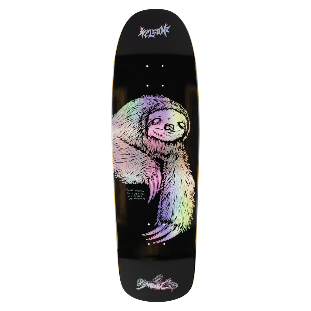 Welcome Sloth on Slappy Slap - Black/Prism Foil skateboard deck: Shaped black deck with a large hand-drawn sloth in holographic prism foil, rainbow-tinted, hanging with long claws. Small handwritten note beside it and a tiny drawing of a skater at the tail. Welcome logo at the top.
