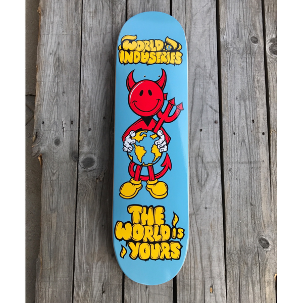 World Industries DevilMan - The World is Yours skateboard deck: Smiling red devil character with a trident, wearing yellow shoes and hugging a globe, on a light blue deck. World Industries logo is at the top and 'The World is Yours' in yellow bubble lettering at the bottom.