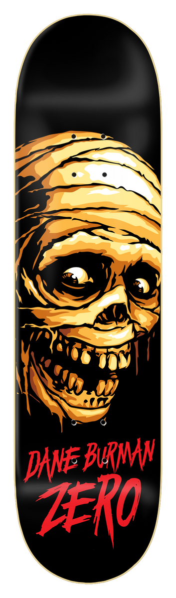 Zero Burman - Mummy 8.5 skateboard deck: Black deck with a large bandaged mummy head in orange and yellow tones with bulging eyes and a gaping toothy grin. Rider name and brand in red drippy lettering at the bottom.