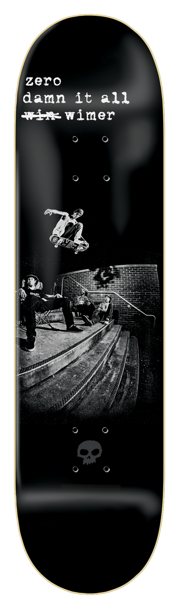 Zero Fs Flip - Wimer 8.25 skateboard deck: Black and white photograph of a skater frontside flipping down a set of steps beside a brick wall, with onlookers seated at left. Rider text at top has 'win' struck out; small grey Zero skull at the tail.