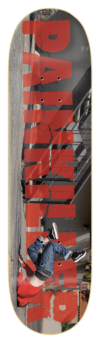 Zero Painkiller 8.375 skateboard deck: Large distressed red 'Painkiller' lettering running sideways over a photo of a skater falling backwards beside a staircase handrail, with the rider's legs in the air. Black border.