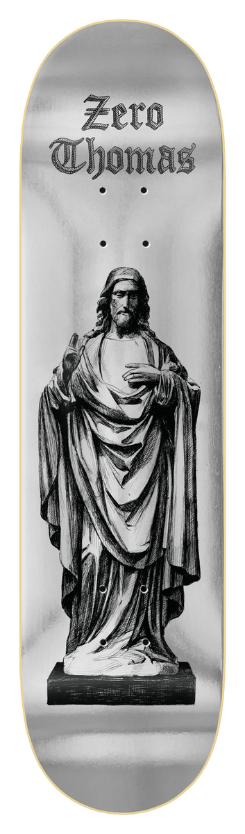 Zero Thomas - Jesus Statue skateboard deck: Black and white engraving-style illustration of a robed statue of Jesus with raised hand, standing on a plinth against a silver foil background. Gothic blackletter 'Zero Thomas' sits at the top.