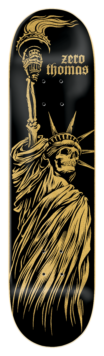 Zero Thomas - Liberty Or Death 8.25 skateboard deck: Black deck with a gold, engraving-style Statue of Liberty with a skull face and skeletal hand holding the torch. Zero Thomas in gold gothic lettering at the upper right.