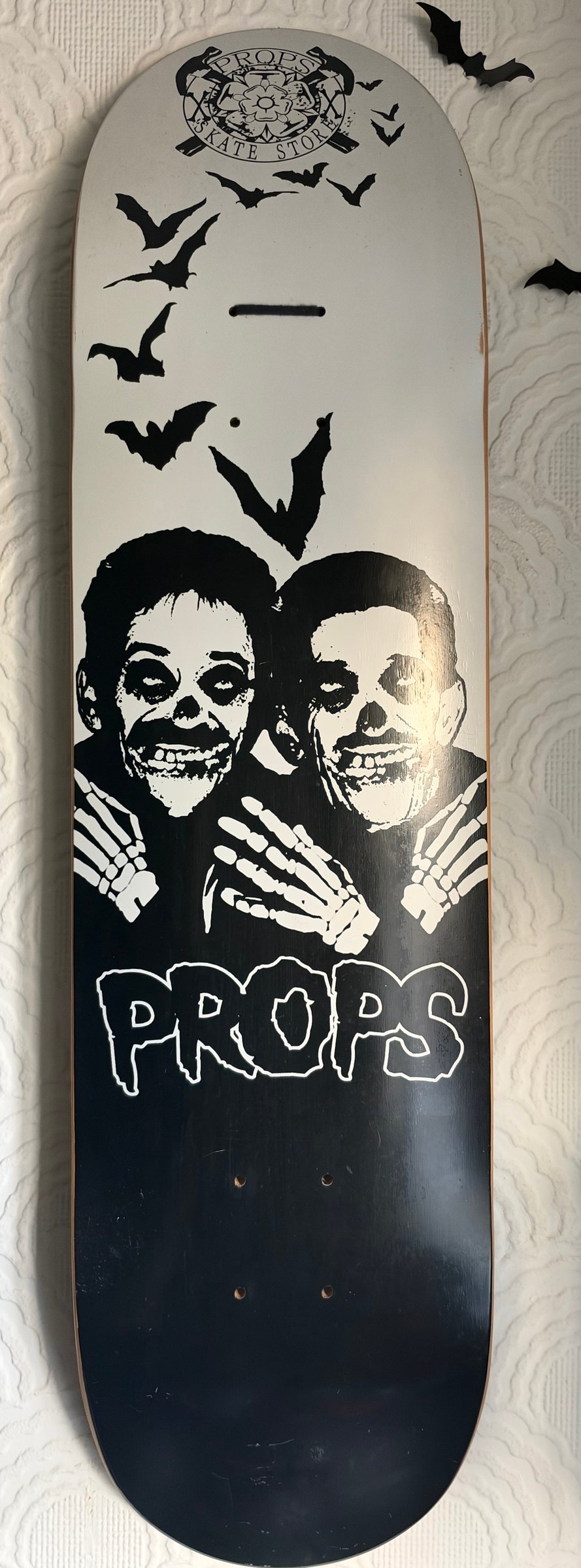 Props skate store Chuckle brothers skateboard deck: Two skeleton-faced figures with painted skull make-up and bony hands on their shoulders, with bats flying above, in black and white horror-punk style. A small circular crest sits at the top and the PROPS logo in dripping letters below.