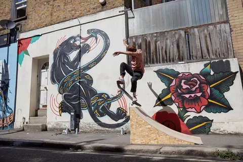 Skating a ramp in front of the panther and rose murals next door by Three Amigos collabs