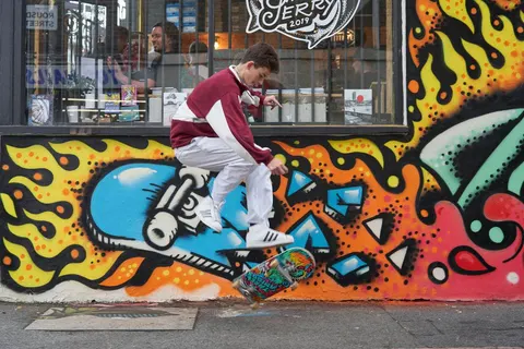 Kickflip in front of the 2019 mural by Three Amigos collabs