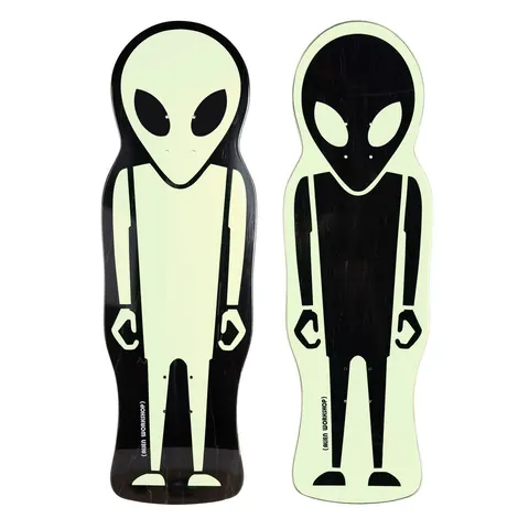 Alien Workshop Soldier Die Cut Glow 9.675 skateboard deck: Two die-cut shaped decks in the outline of a standing alien figure in glow-in-the-dark pale green and black, one pale alien on black and the other black alien on pale green. Brand name in small print at the tail.