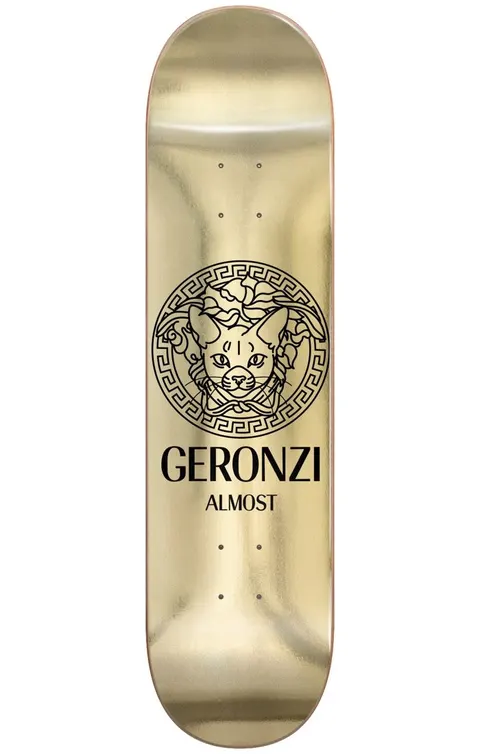 Almost Max Runway R7 8.5 skateboard deck: A black line drawing of a cat's head inside an ornate Greek-key medallion, in the style of a luxury fashion logo, on a shiny gold foil deck. 'Geronzi' and 'Almost' are printed below in black.