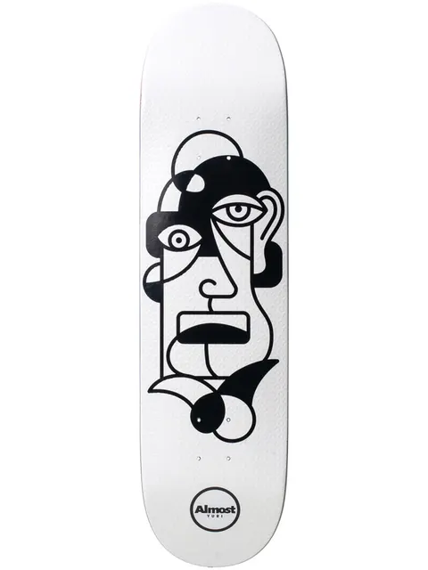 Almost Twisted Yuri R7 skateboard deck: Abstract black line-drawn face in a cubist style, with mismatched eyes, a rectangular mouth and curling shapes at the chin, on a white deck. Round Almost Yuri logo at the tail.