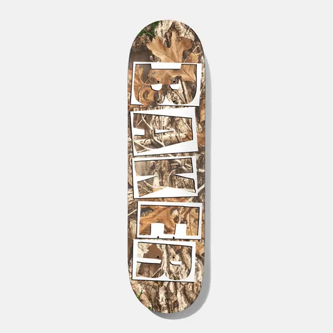 Baker Tyson Trees 8.5 skateboard deck: Realistic woodland camouflage photo print of leaves, bark and branches, with the Baker logo in stacked white outlined block letters cut out down the length of the deck.