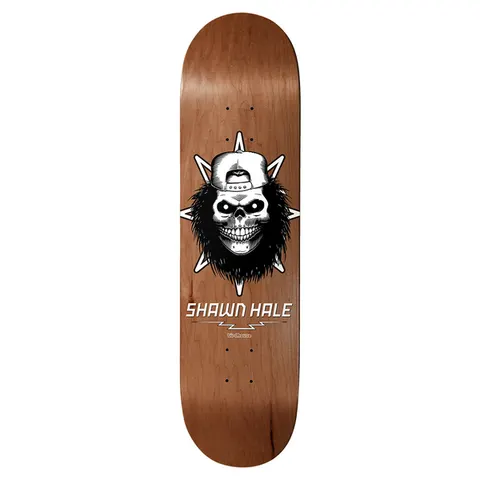 Birdhouse Hale Skull 8.63 skateboard deck: A grinning skull wearing a backwards cap with dark shaggy hair, set in front of a spiked star, with the rider name and a lightning bolt underneath, printed on a natural brown wood-stained deck.