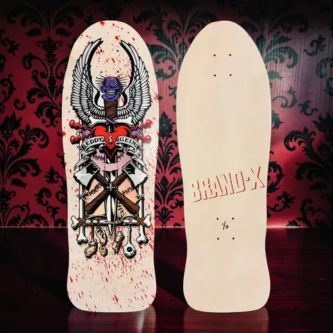 Brand-X Ed Gein Blood Splatter skateboard deck: An old-school graphic of a winged, purple skull impaled on a dagger through a red heart, with crossed axes, stitched limbs, bones, an ear and an eyeball, and a banner reading Eddy Geini. Red blood splatter across a natural wood deck; the photo also shows the blank back with Brand-X.