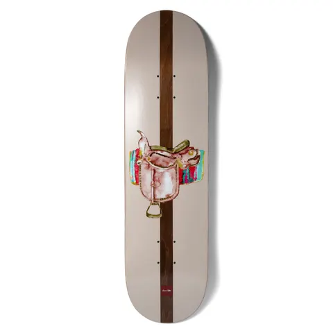 Chocolate Alvarez Save A Horse skateboard deck: A watercolour-style western saddle on a colourful striped blanket, centred over a dark brown wood-stained stripe running the length of the deck, on a pale taupe background.