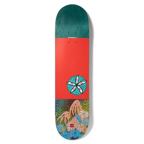 Chocolate Anderson Dog Perfume skateboard deck: Teal-stained top section, a red-orange middle with embossed fern pattern and a round teal medallion of five white eyes or petals. The base shows a painted jungle of leaves and tangled pink roots. Signature at the top and Chocolate logo at the bottom.