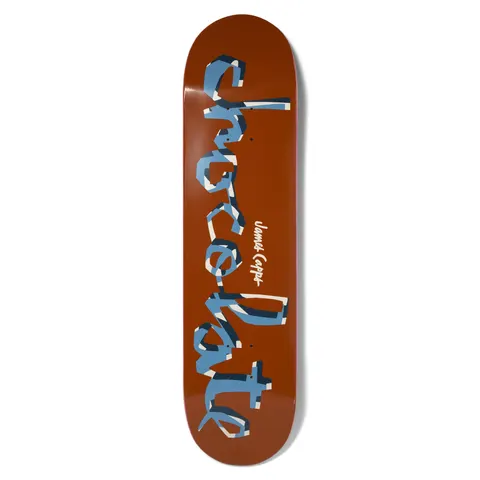 Chocolate Capps Original Chunk Pop Secret skateboard deck: The Chocolate hand-lettered 'chunk' logo runs the full length of a rust-brown deck, filled in blue with white and navy ribbon-like stripes. A small 'James Capps' signature sits at the centre.